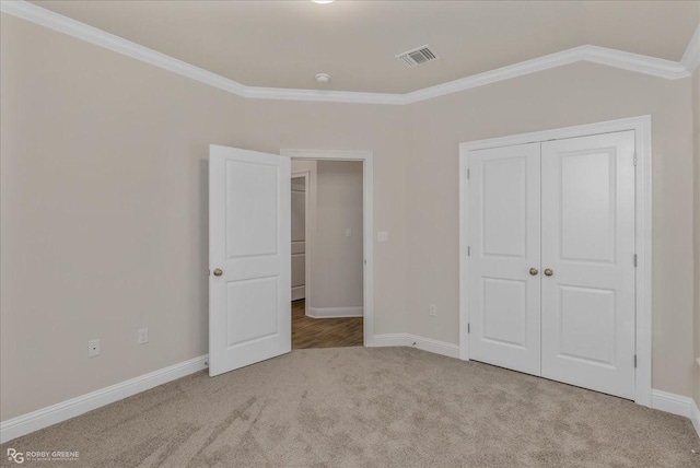 unfurnished bedroom featuring light carpet, a closet, vaulted ceiling, and ornamental molding