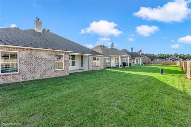 rear view of property featuring a lawn