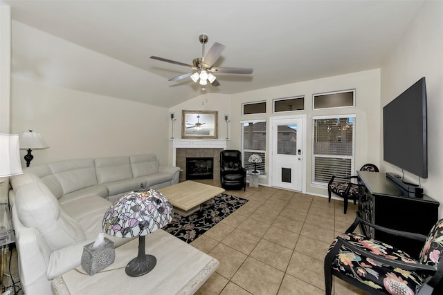 living room with a fireplace, light tile patterned floors, vaulted ceiling, and ceiling fan