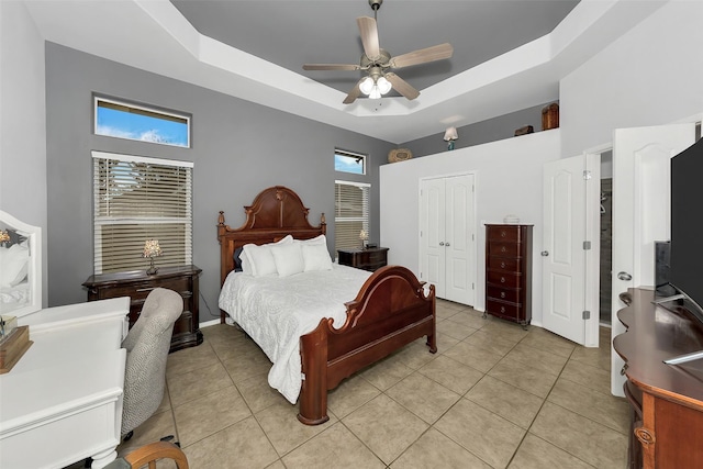 bedroom featuring ceiling fan, a closet, light tile patterned floors, and multiple windows