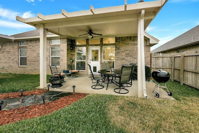 exterior space with a patio area, ceiling fan, a yard, and a fire pit