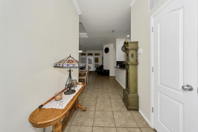 hall with french doors and light tile patterned floors