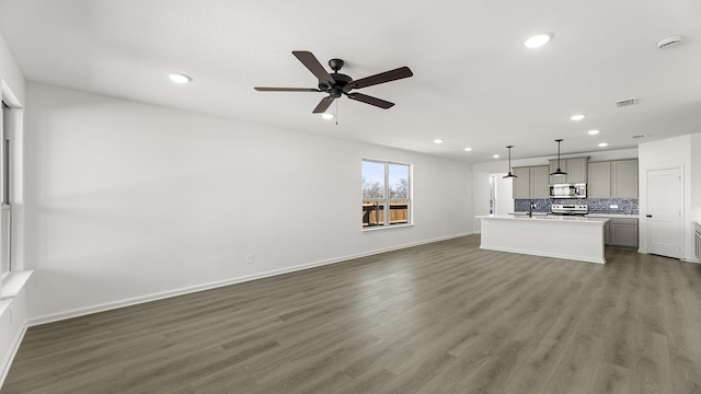 unfurnished living room featuring a ceiling fan, recessed lighting, dark wood finished floors, and baseboards