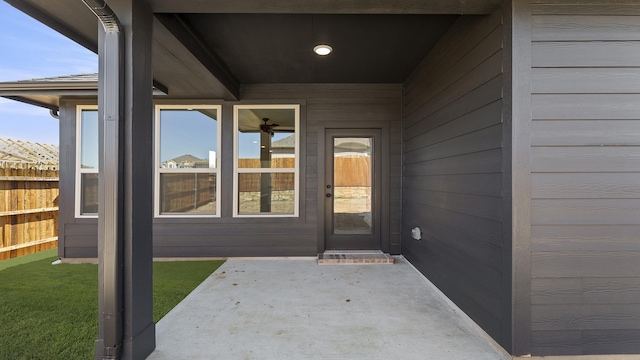 property entrance with fence and a patio