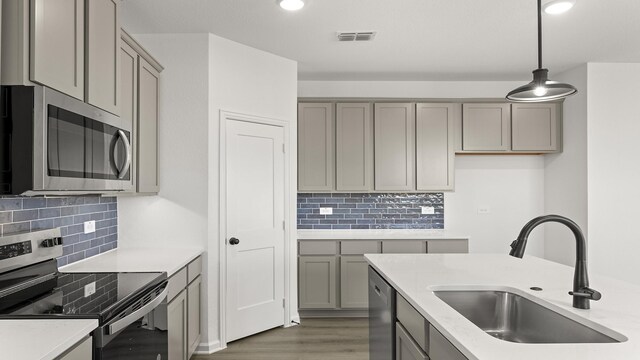 kitchen with sink, white cabinets, hanging light fixtures, stainless steel appliances, and light stone countertops