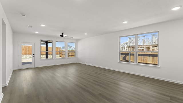 unfurnished room with dark wood-style floors, visible vents, a wealth of natural light, and recessed lighting