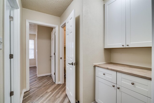 laundry room featuring washer and dryer, cabinets, light tile patterned floors, and a textured ceiling