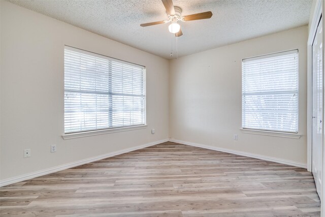 unfurnished bedroom featuring ceiling fan, light wood-type flooring, a textured ceiling, and a closet