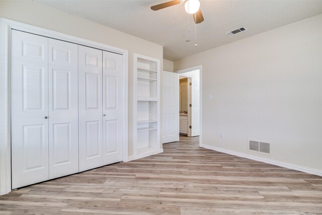 living room with wood-type flooring, a textured ceiling, ceiling fan, and ornamental molding