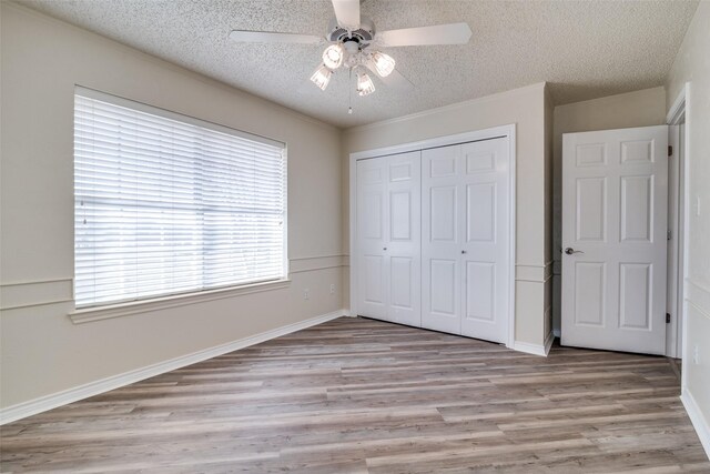 spare room featuring a textured ceiling and light hardwood / wood-style floors