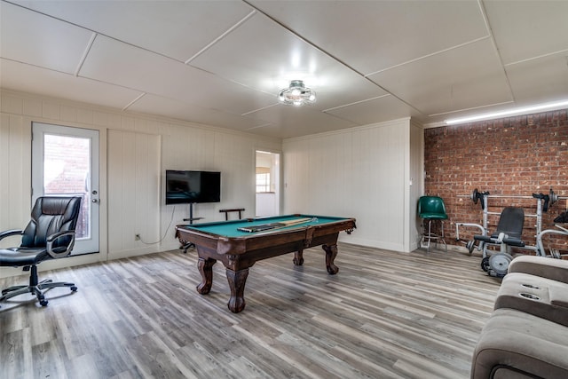 game room with pool table, brick wall, and hardwood / wood-style flooring