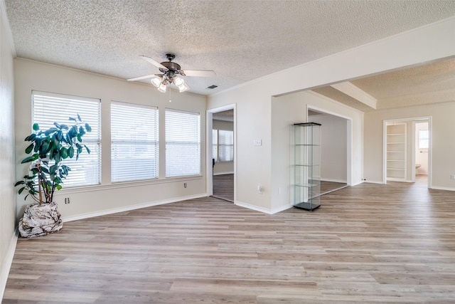 spare room featuring ceiling fan, a textured ceiling, and light wood-type flooring