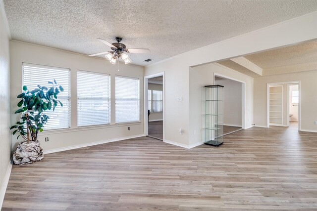 kitchen with a healthy amount of sunlight, white cabinetry, light hardwood / wood-style flooring, and stainless steel appliances