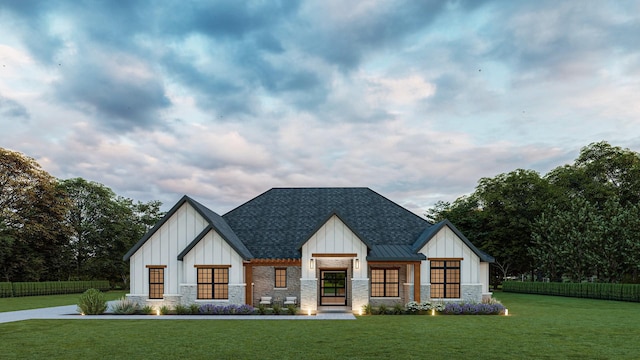 modern farmhouse style home featuring a shingled roof, board and batten siding, a front yard, a standing seam roof, and stone siding