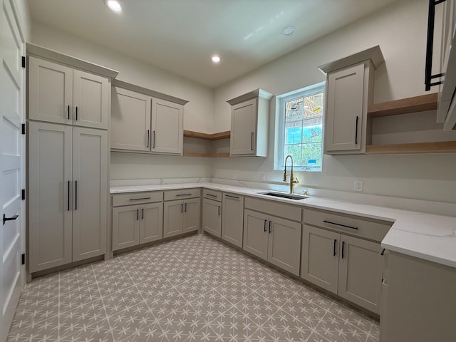 325 Ryker Ln, Gunter, TX 75058 - kitchen with open shelves, a sink, gray cabinets, recessed lighting, and light stone countertops