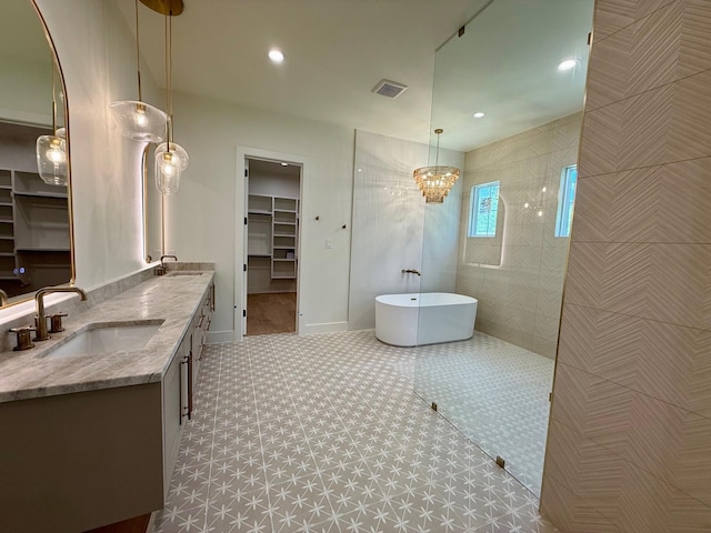 325 Ryker Ln, Gunter, TX 75058 - bathroom featuring a freestanding bath, double vanity, a walk in closet, baseboards, and a walk in shower