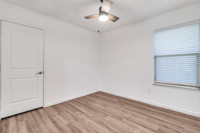 spare room with light wood-style floors, plenty of natural light, baseboards, and ceiling fan