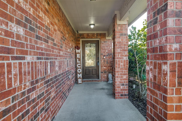 view of exterior entry featuring brick siding