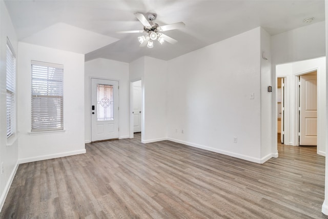 foyer entrance with ceiling fan, light wood finished floors, and baseboards