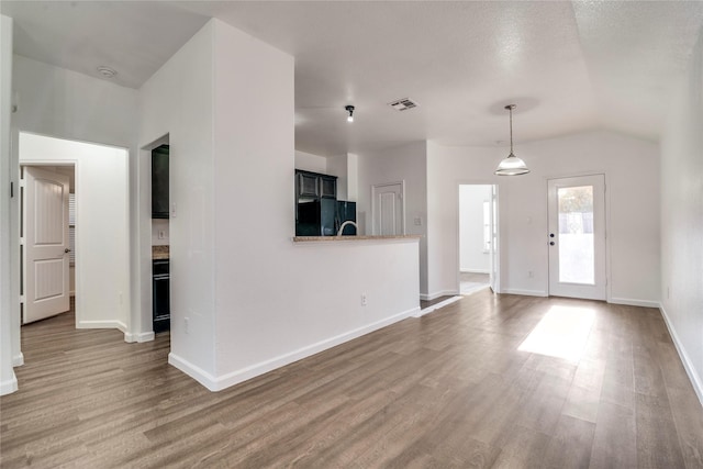 unfurnished living room with wood-type flooring and lofted ceiling