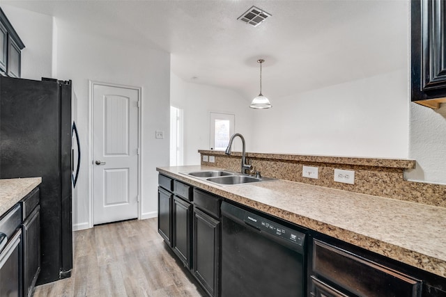 kitchen with sink, black appliances, decorative light fixtures, and light hardwood / wood-style flooring