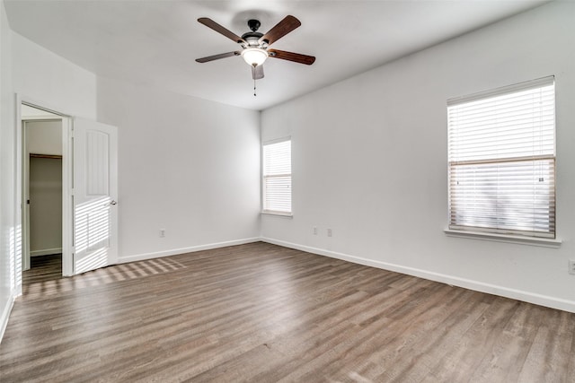 unfurnished room with ceiling fan, baseboards, and wood finished floors