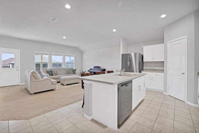 kitchen featuring white cabinets, sink, an island with sink, appliances with stainless steel finishes, and light colored carpet