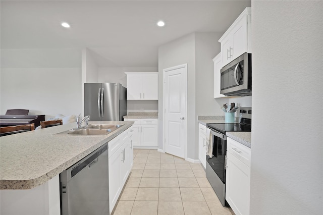 kitchen featuring appliances with stainless steel finishes, white cabinetry, an island with sink, sink, and light tile patterned floors