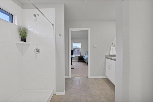 bathroom with vanity, plenty of natural light, tiled shower, and tile patterned floors