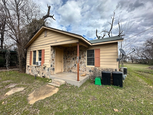 view of front of home featuring cooling unit and a front yard