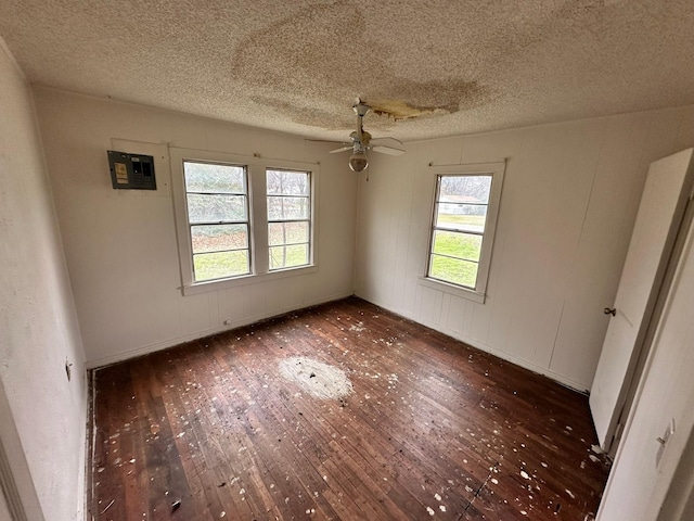 unfurnished room with ceiling fan, a textured ceiling, and dark hardwood / wood-style flooring