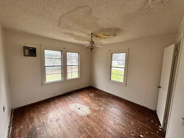 spare room featuring a textured ceiling, ceiling fan, dark hardwood / wood-style flooring, and plenty of natural light