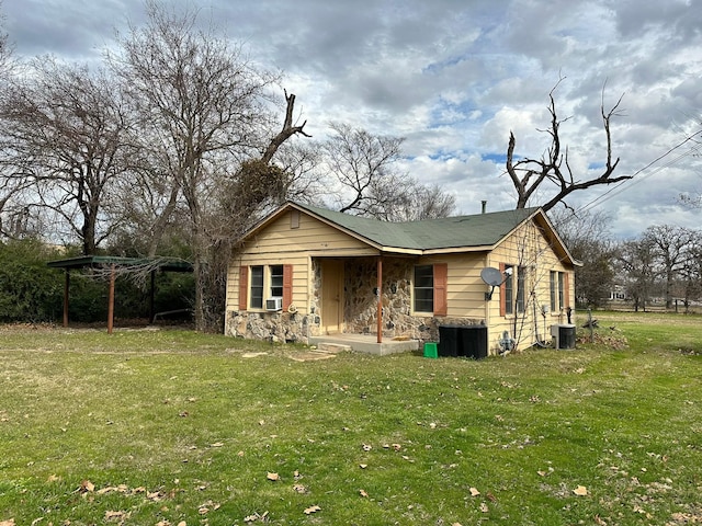 view of front of house featuring a front lawn and cooling unit