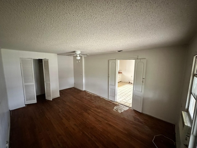 unfurnished bedroom featuring a textured ceiling and dark hardwood / wood-style flooring