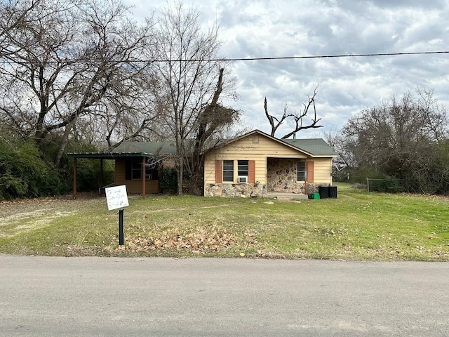 view of front of property featuring a front lawn and a carport