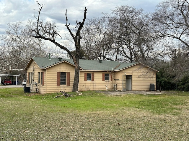 back of property with a lawn and central air condition unit