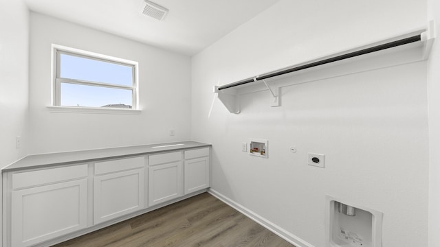 clothes washing area featuring hookup for an electric dryer, gas dryer hookup, light wood-style flooring, visible vents, and hookup for a washing machine