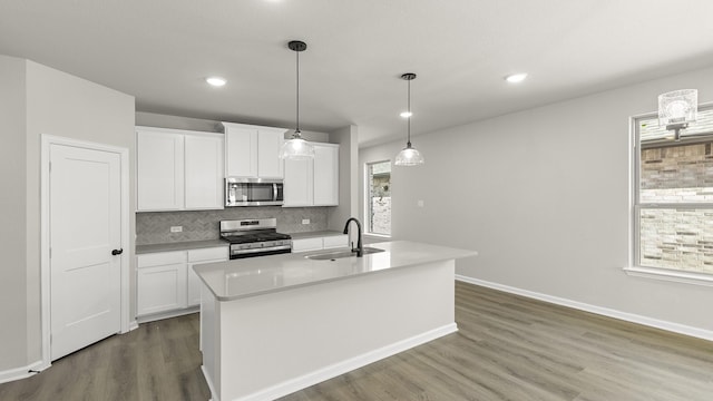 kitchen with a sink, a healthy amount of sunlight, dark wood-style flooring, and stainless steel appliances