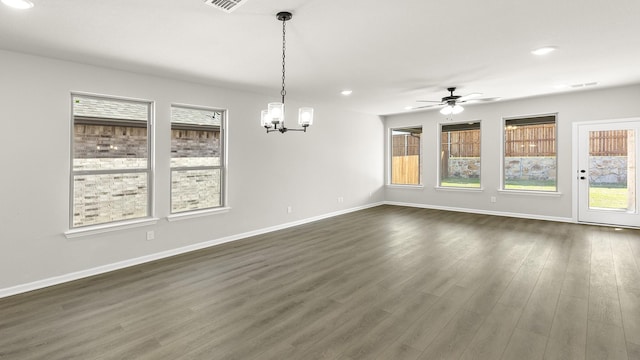 unfurnished dining area with baseboards, plenty of natural light, and ceiling fan with notable chandelier