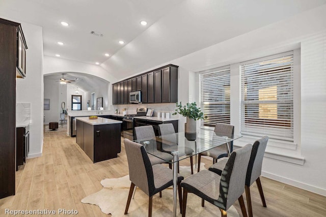 dining area featuring vaulted ceiling, ceiling fan, and light wood-type flooring