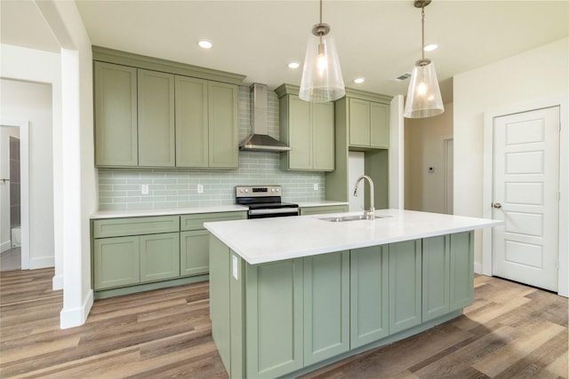 kitchen featuring green cabinetry, light hardwood / wood-style flooring, stainless steel range with electric stovetop, and wall chimney range hood