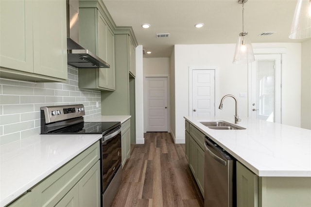 kitchen with pendant lighting, wall chimney range hood, sink, dark hardwood / wood-style floors, and appliances with stainless steel finishes