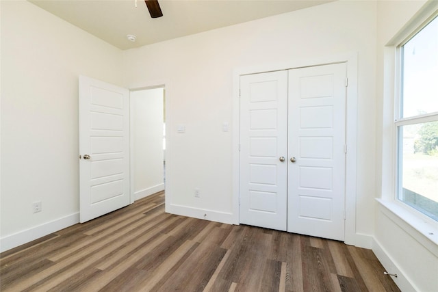 unfurnished bedroom with a closet, ceiling fan, and dark hardwood / wood-style flooring