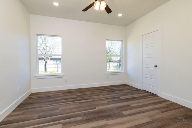 spare room featuring dark hardwood / wood-style flooring, ceiling fan, and a healthy amount of sunlight