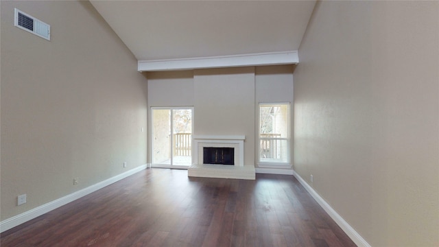 unfurnished living room featuring a high ceiling, dark hardwood / wood-style flooring, and a brick fireplace