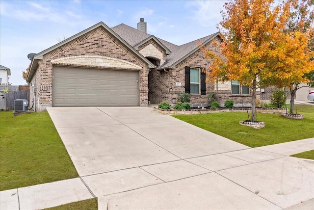 view of front of home featuring cooling unit, a garage, and a front yard