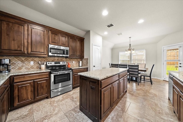 kitchen featuring dark brown cabinets, stainless steel appliances, decorative light fixtures, an inviting chandelier, and lofted ceiling