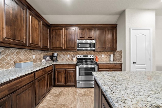 kitchen featuring decorative backsplash, appliances with stainless steel finishes, light stone counters, dark brown cabinetry, and a textured ceiling