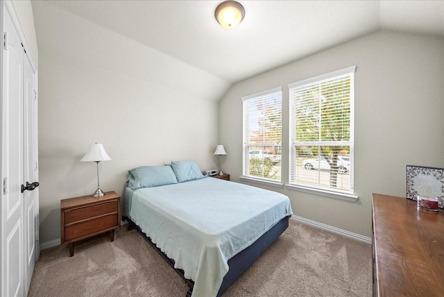 carpeted bedroom featuring vaulted ceiling