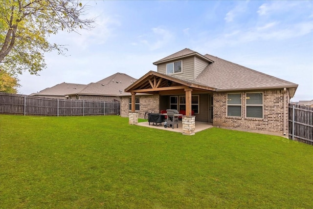 rear view of property with a yard and a patio